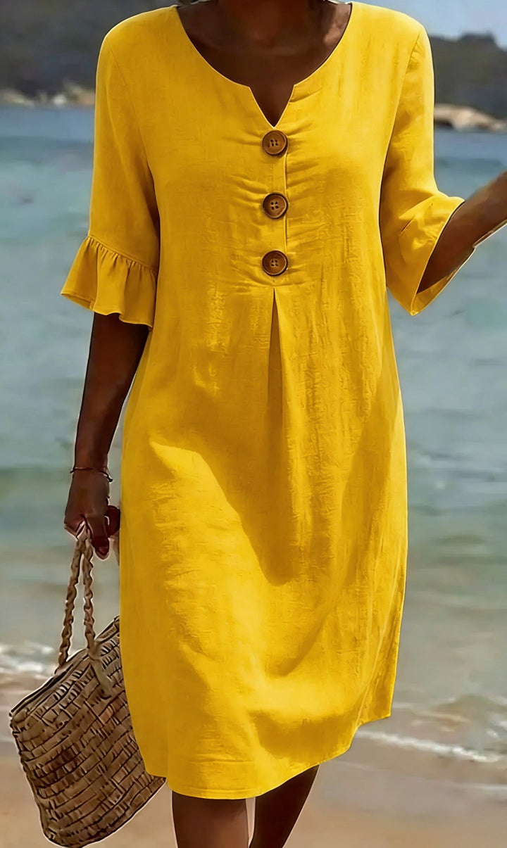 Détail de la robe femme en coton lin: boutonnage élégant et manches volantées pour un look estival.