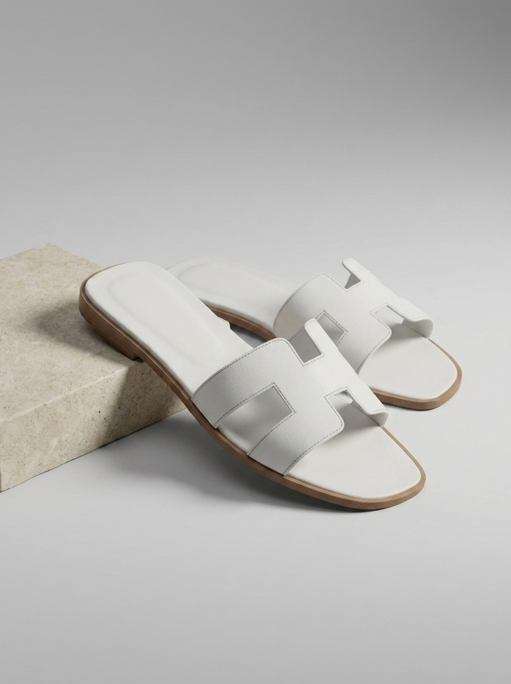 Mules plates femme, chaussures été confortables en cuir synthétique, design élégant à bride en H. Style minimaliste.