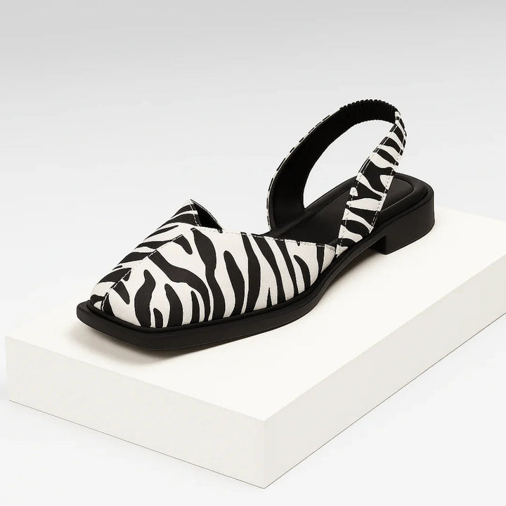 Femme portant des ballerines imprimées bout ouvert, élégantes et confortables pour casual ou soirée.