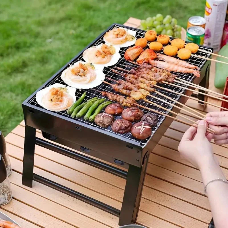 Barbecue de table pliable en métal léger et compact, idéal pour camping, structure en métal robuste et grille en acier.