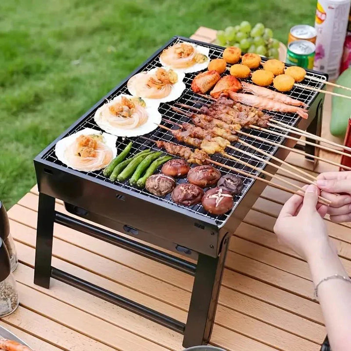 Barbecue de table pliable en métal léger et compact, idéal pour camping, structure en métal robuste et grille en acier.