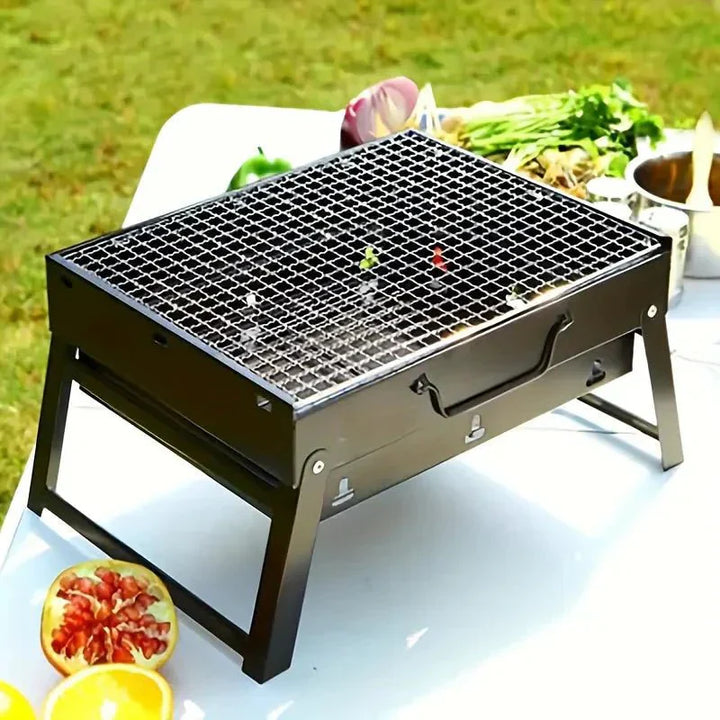 Barbecue de table pliable en métal léger et compact, idéal pour camping, structure en métal robuste et grille en acier.