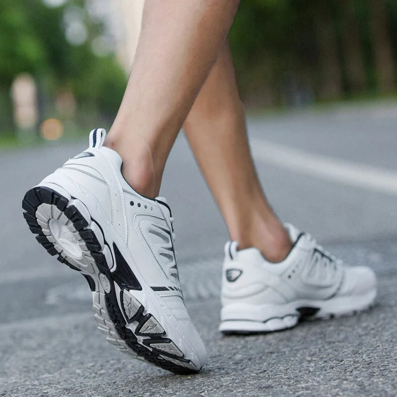 Chaussures de sport hommes en maille respirante noire, semelle EVA blanche, confort optimal pour marche quotidienne.