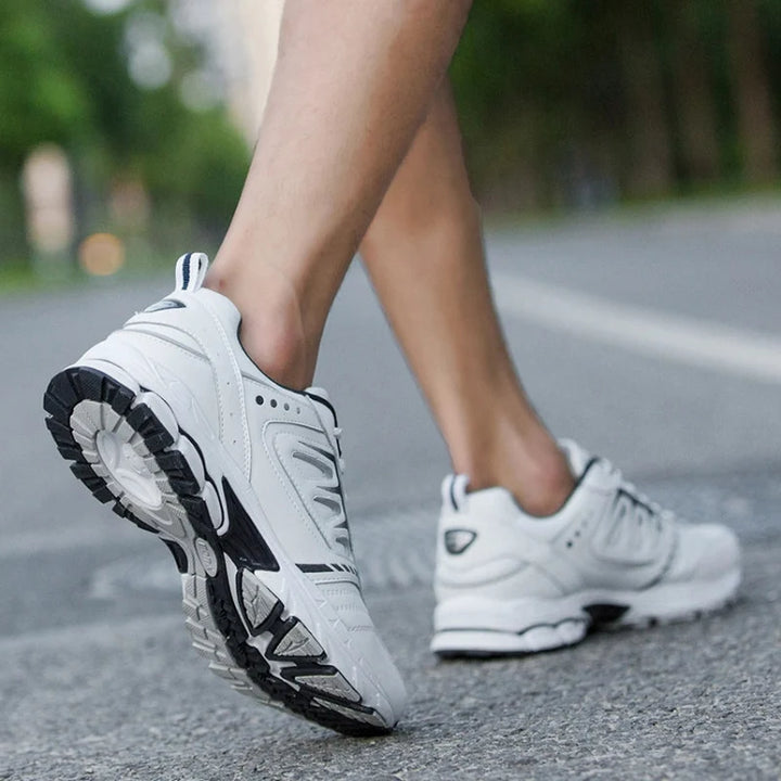 Chaussures de sport hommes en maille respirante noire, semelle EVA blanche, confort optimal pour marche quotidienne.