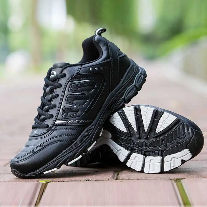 Baskets noires et blanches pour hommes, style moderne, respirantes, pour la gym, la course ou les loisirs.