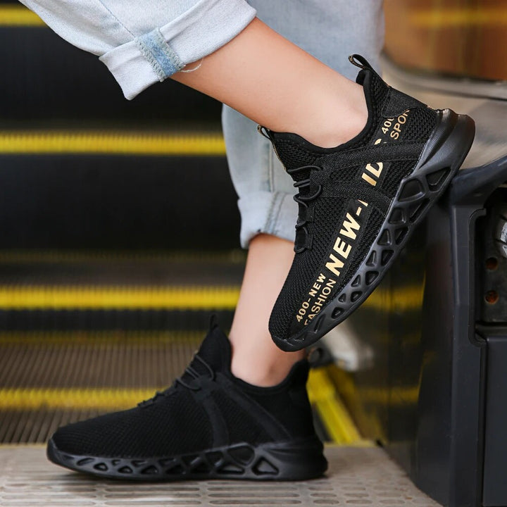 Paire de baskets enfants tricotées noires et blanches, parfaites pour un style actif et quotidien.