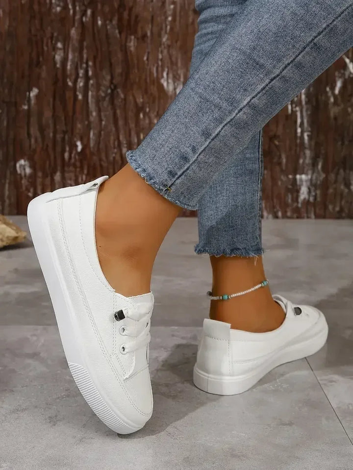 Mode féminine : baskets blanches plates pour femmes. Chaussures à lacets offrant un style décontracté et un confort optimal.