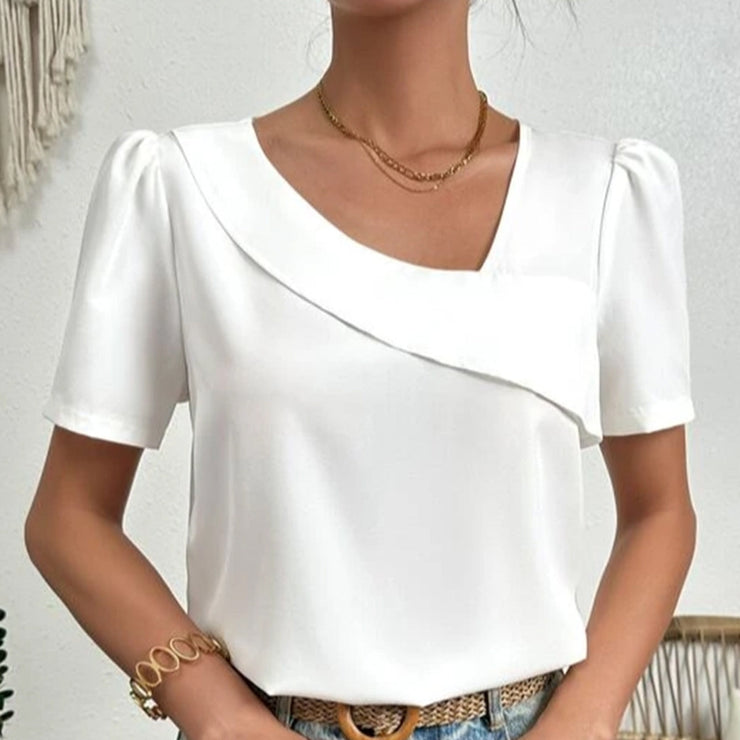 Blouse blanche été, col asymétrique, manches bouffantes. Style féminin et léger.