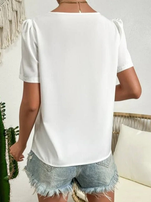 Blouse blanche été, col asymétrique, manches bouffantes. Style féminin et léger.