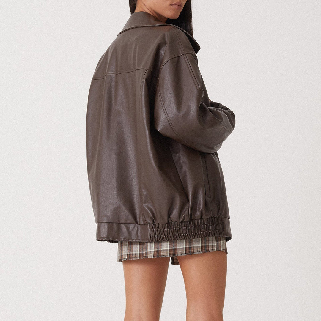 Blouson en cuir synthétique femme style motard, coupe féminine, fermeture zippée asymétrique, poches latérales zippées.