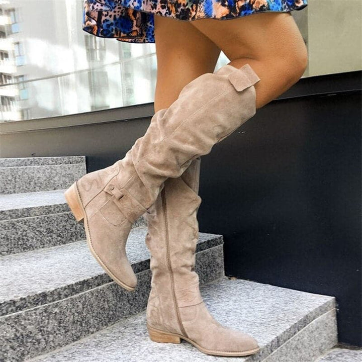 Bottes en daim élégantes pour femmes avec lanières et boucles décoratives, coupe ample pour confort quotidien.