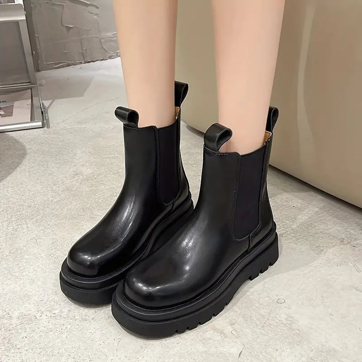 Femme portant bottes plateforme noires chic avec jean. Chaussures mode élégantes et confortables, polyvalentes pour l'hiver.
