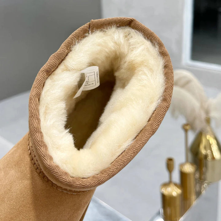 Femme portant des bottines d'hiver en daim élégantes, alliant chaleur et confort pour un look chic.