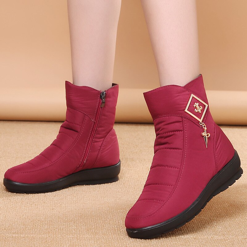 Gros plan sur les bottines de neige femme avec leur doublure en fourrure moelleuse et leur semelle robuste.