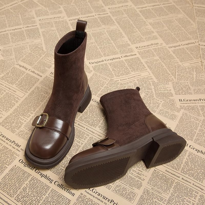 Gros plan sur la boucle décorative des bottines élégantes femmes noires, design chic et tendance automne.