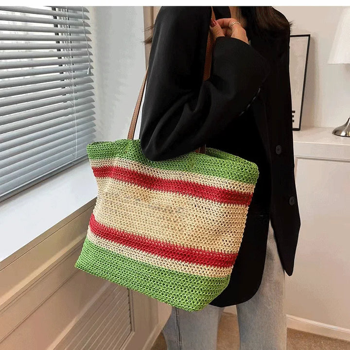 Accessoire de mode féminin: grand sac en paille naturelle et lanières de cuir, style été décontracté et chic.