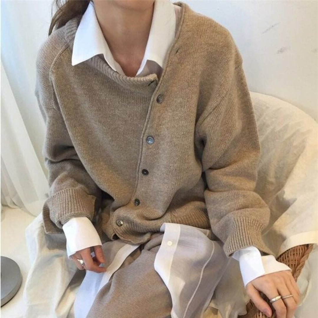 Cardigan femme élégant en maille douce, boutonnage asymétrique unique. Idéal pour un style automnal chic et confortable.