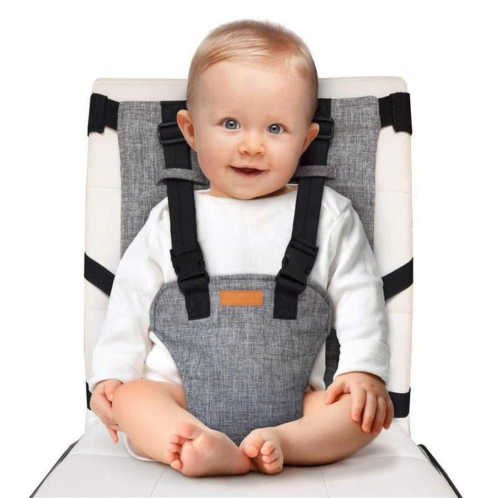 "Chaise haute de voyage bébé compacte, design innovant, sangles et harnais réglables, couleur neutre, portable et sécurisée."