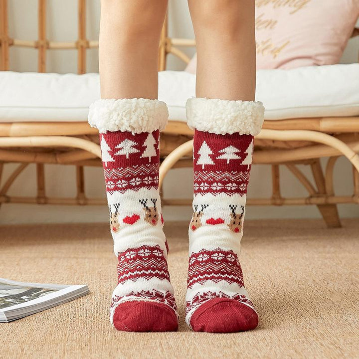 Femme portant des chaussettes chaudes antidérapantes, scène de détente à la maison en hiver.