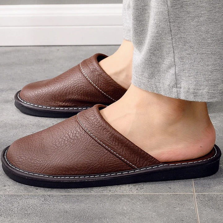 Pantoufles de luxe en cuir noir pour homme, idéales pour le confort intérieur et la relaxation.
