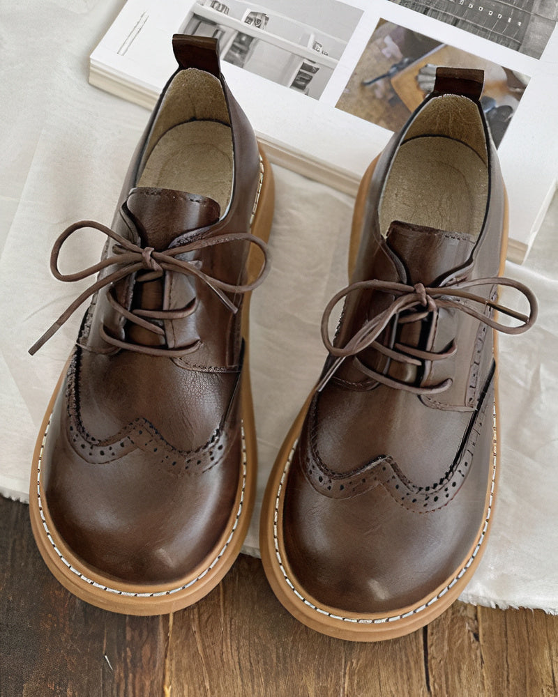 Chaussures Oxford femme élégantes en cuir noir à lacets. Style classique intemporel pour tenue de bureau ou quotidienne.