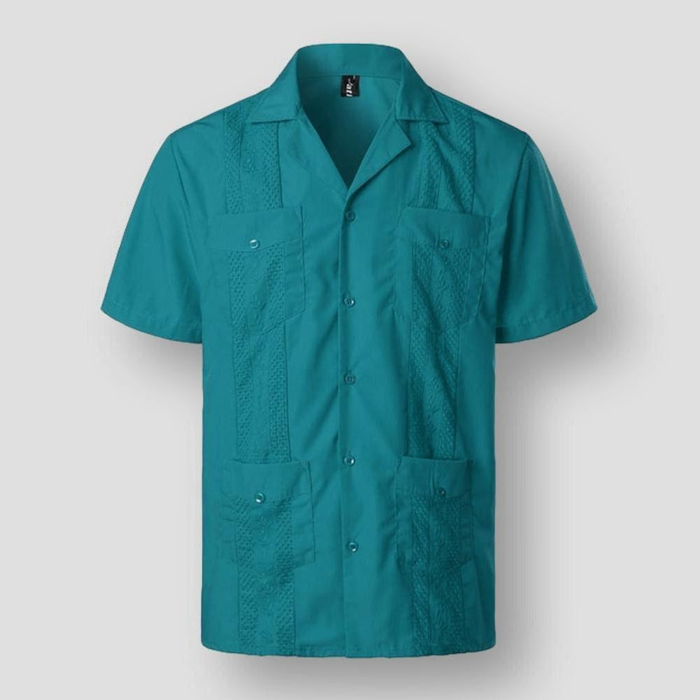 "Chemise brodée homme style tropical, motifs détaillés, tissu doux, couleurs variées pour élégance et confort insulaires."