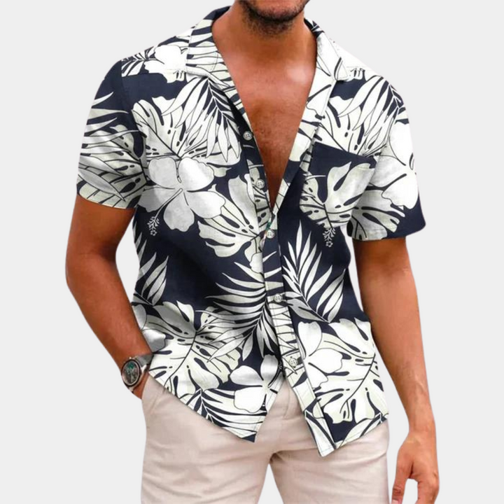 Gros plan sur le motif floral d'une chemise homme à manches courtes, esprit estival et plage.