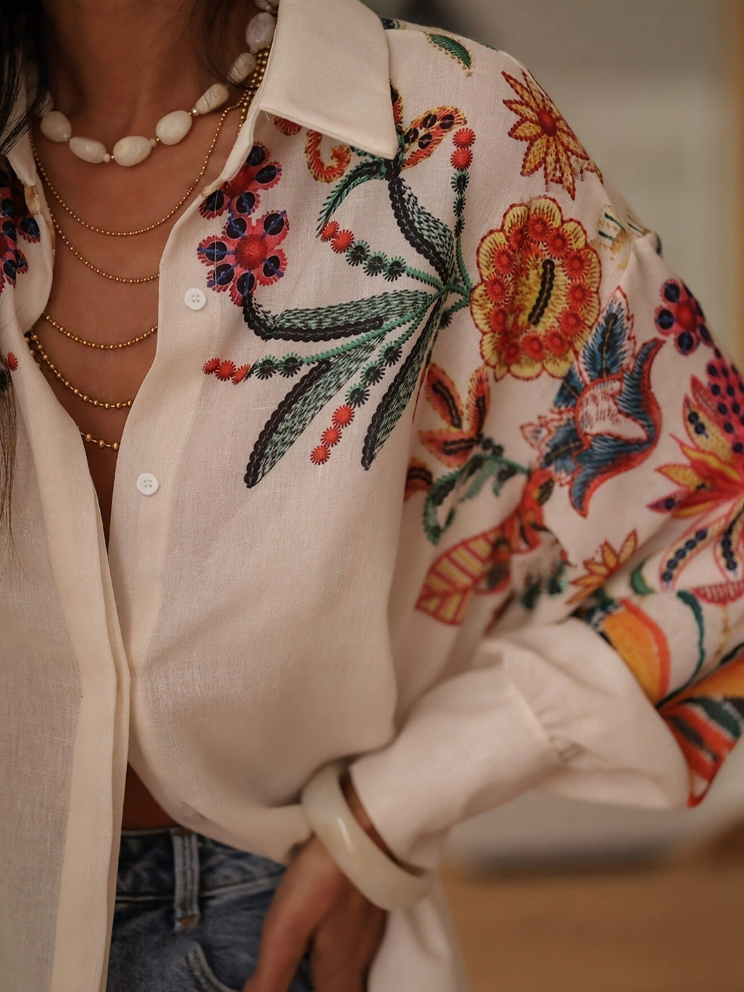 Femme portant un chemisier tunique bohème à manches longues, broderie florale, style printanier décontracté.