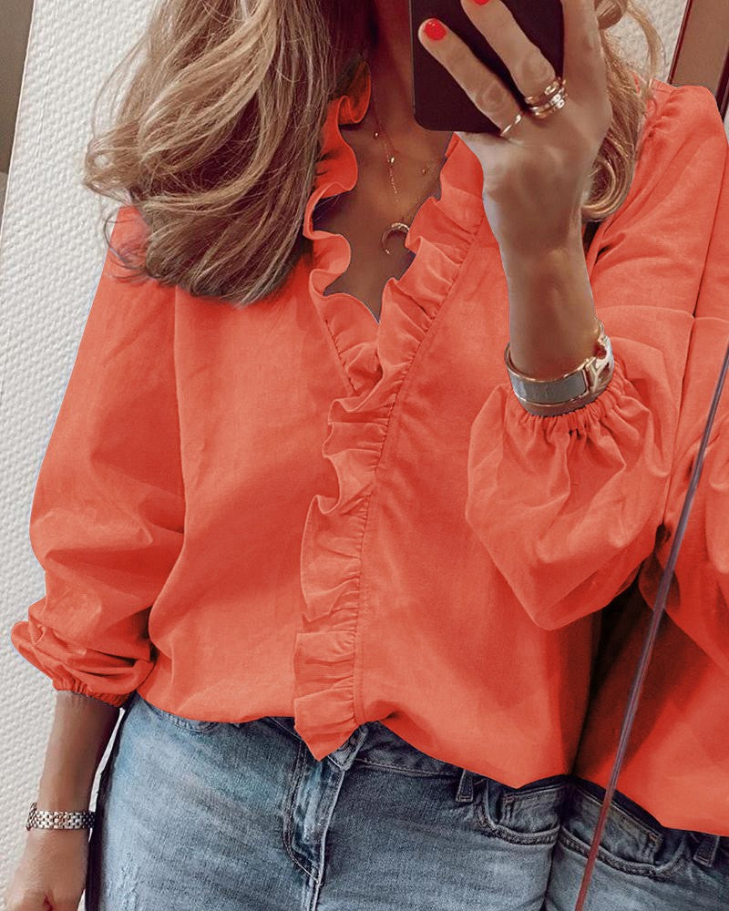 Chemisier femme printanier à volants et manches lanterne, coupe élégante pour un look décontracté chic.