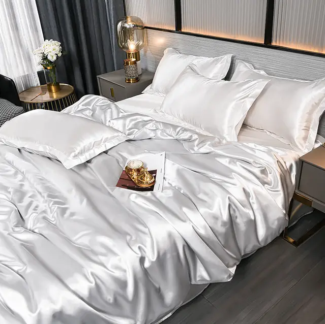 "Draps unis en satin brillant, texture soyeuse, disponibles en diverses tailles et couleurs pour une chambre élégante."