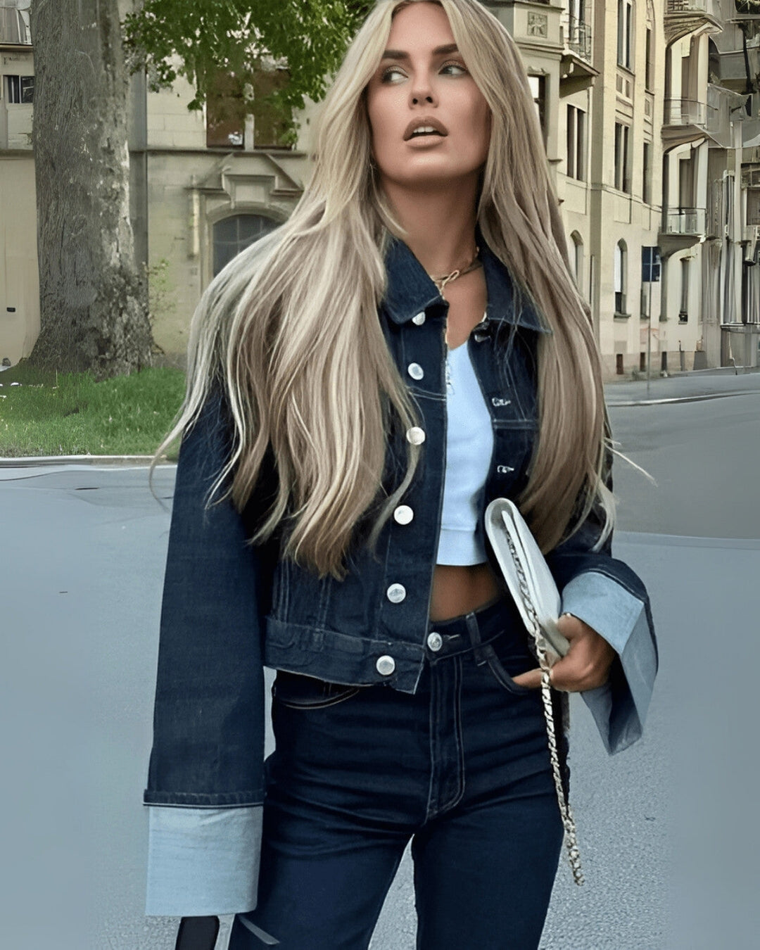 Modèle portant un ensemble veste et pantalon long en denim bleu foncé, affichant un style féminin et moderne.