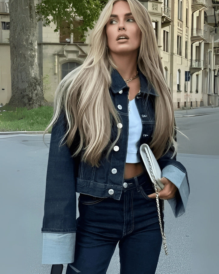 Modèle portant un ensemble veste et pantalon long en denim bleu foncé, affichant un style féminin et moderne.