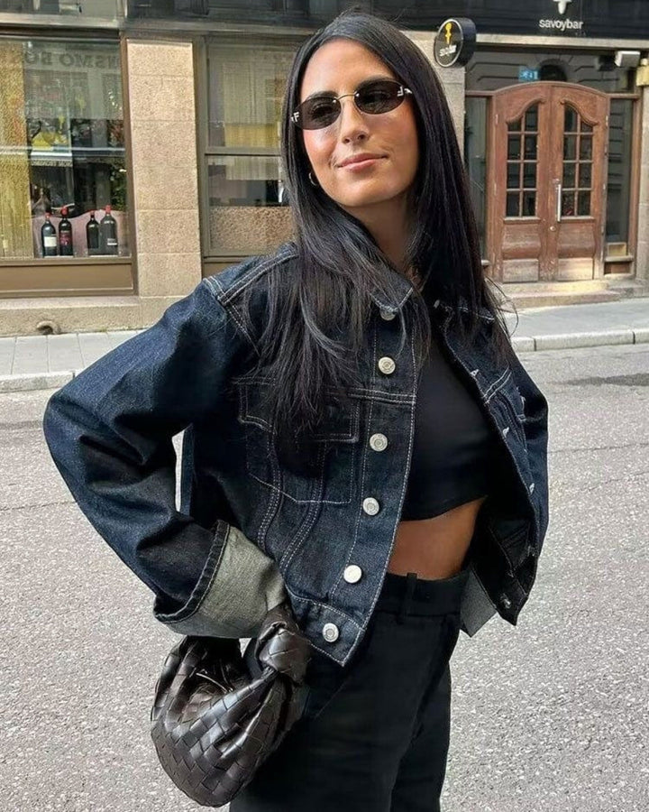 Détail de l'ensemble chic en jean femme bleu foncé : veste ajustée et pantalon long pour une silhouette élégante.