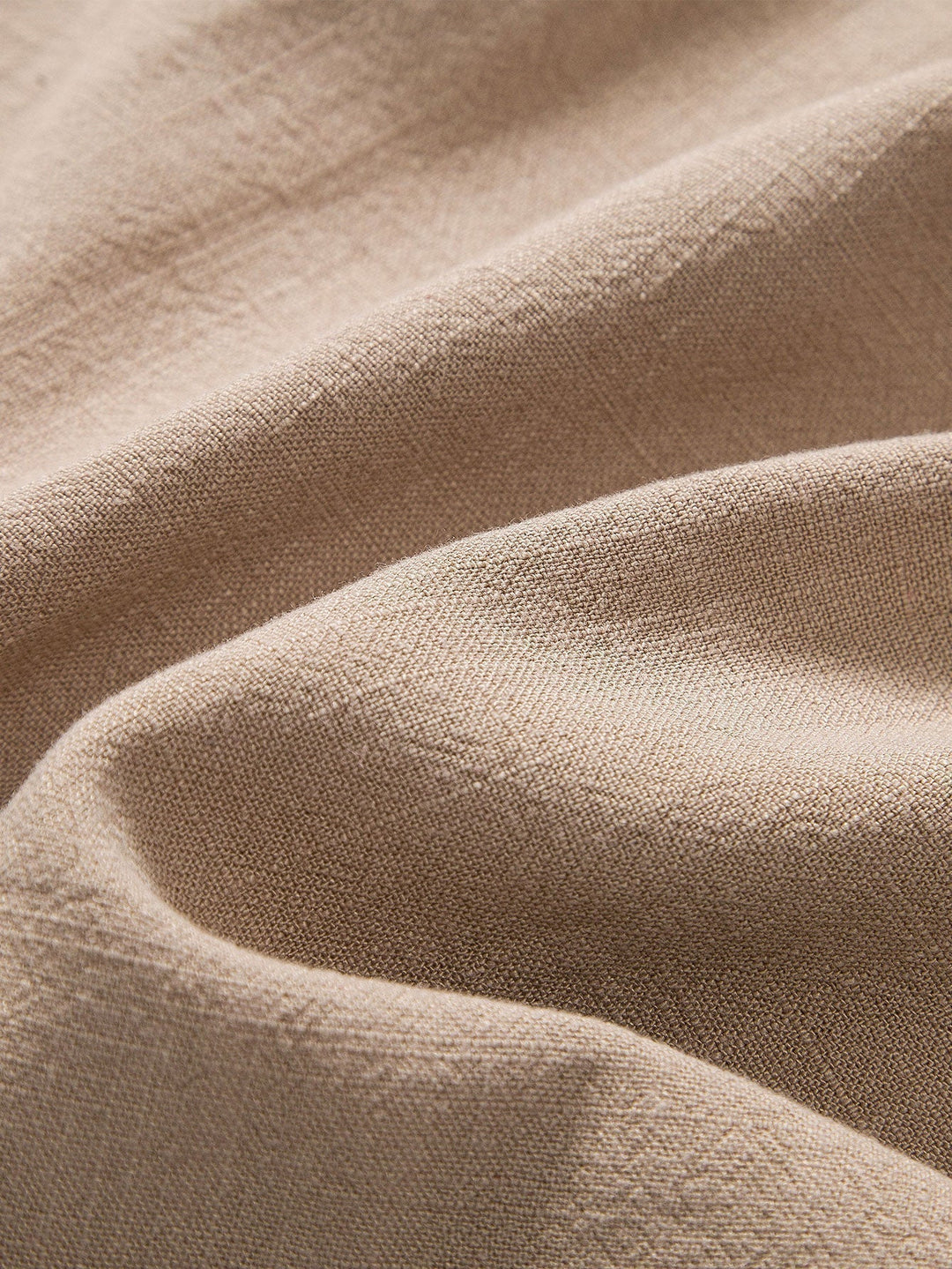 Gros plan sur la texture du lin de cette tenue homme d'été, synonyme de fraîcheur et de qualité.