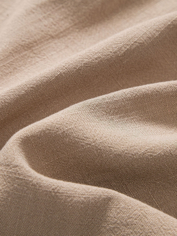 Gros plan sur la texture du lin de cette tenue homme d'été, synonyme de fraîcheur et de qualité.