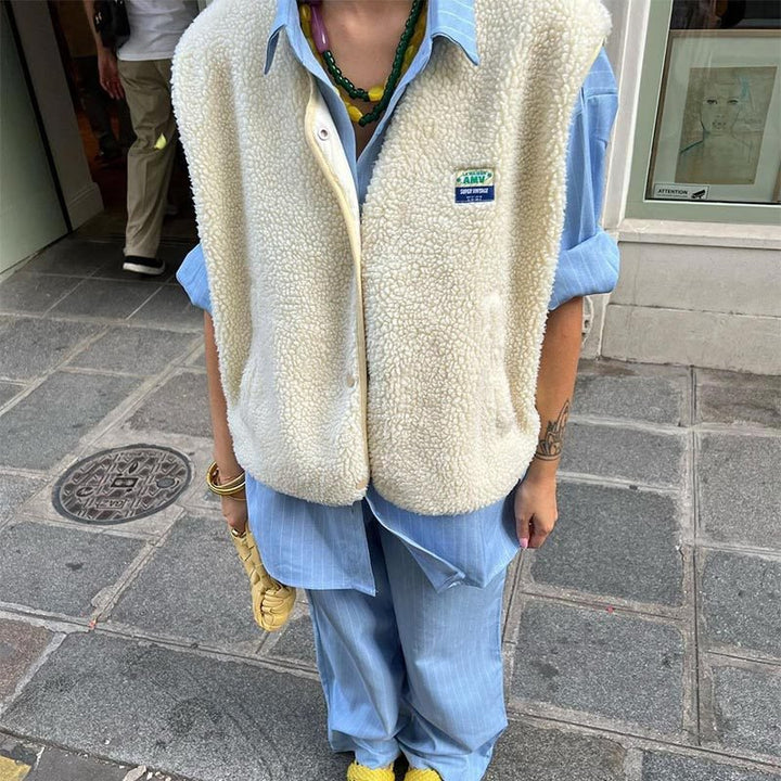 Vue de face d'un gilet femme élégant, sans manches, boutons apparents, mode hiver.