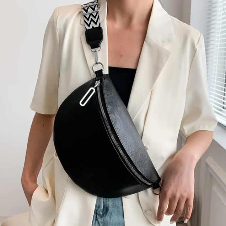 Grand sac banane femme élégant noir en similicuir, porté bandoulière, parfait pour la mode quotidienne.