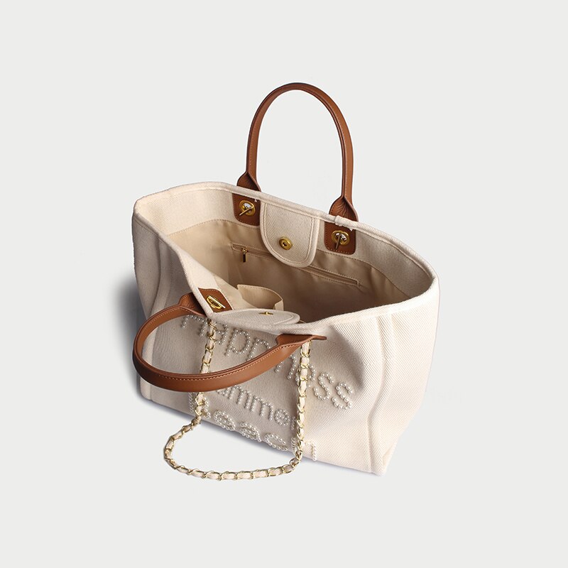 Grand sac cabas femme élégant en toile crème brodée de perles, idéal pour l'épaule. Style tendance.