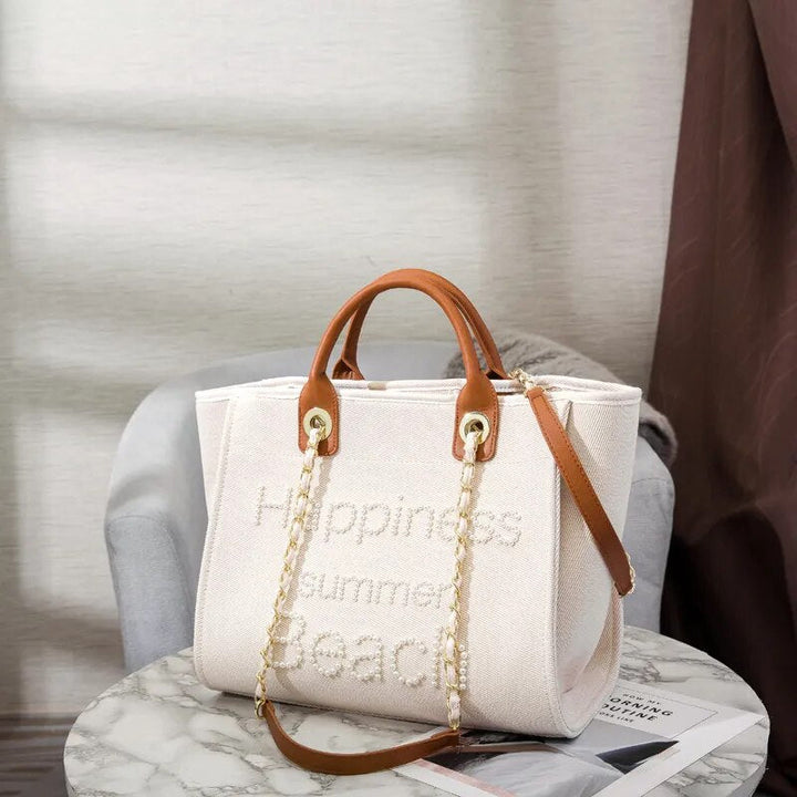 Sac cabas femme tendance en toile canvas crème avec broderies et perles. Grand fourre-tout d'épaule.