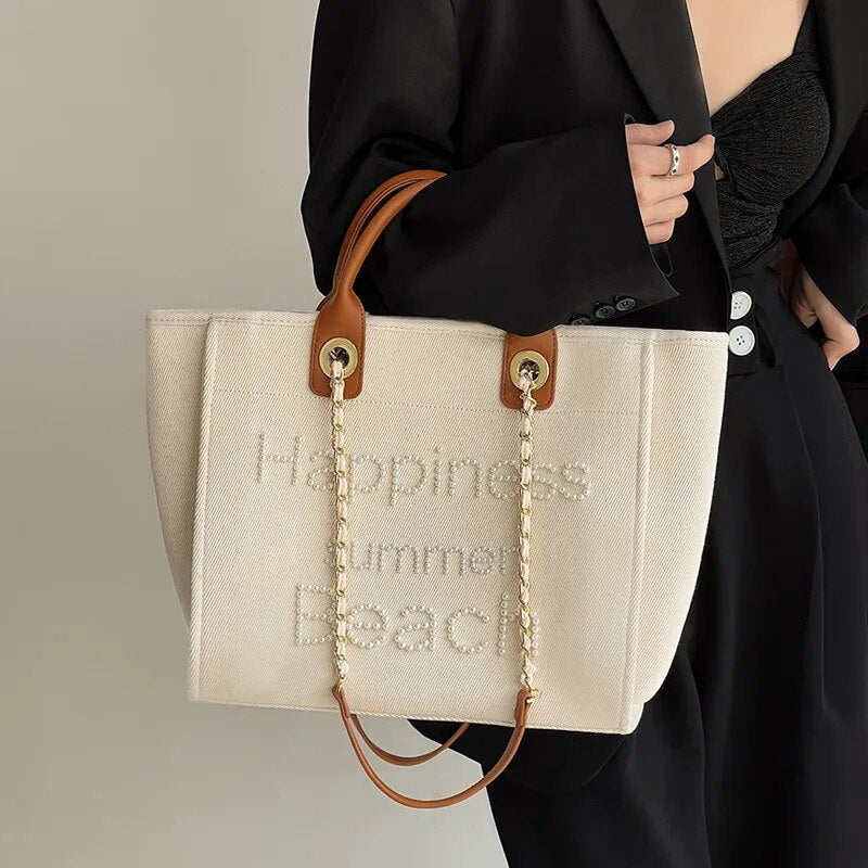 Sac cabas femme tendance en canvas crème brodé de perles. Grand et élégant, parfait comme sac d'épaule.