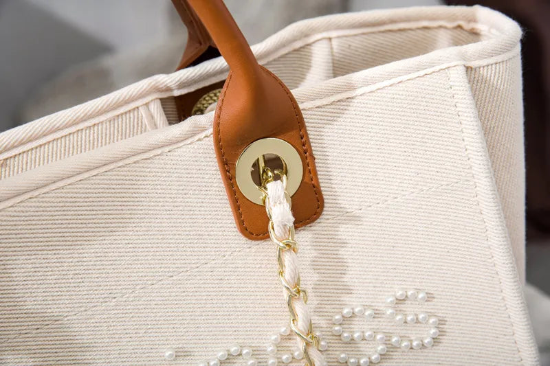 Grand sac cabas femme élégant en toile crème brodée de perles. Sac d'épaule fourre-tout tendance.