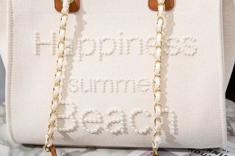 Fourre-tout femme grand format en toile canvas crème. Sac cabas brodé de perles, élégant et tendance pour l'épaule.