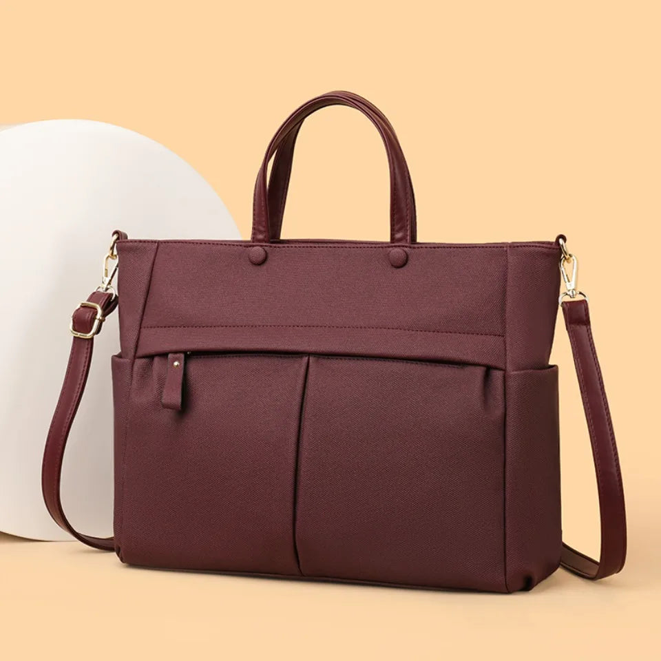 Sac de travail femme Élise en tissu technique noir, porté épaule, style moderne et pratique.