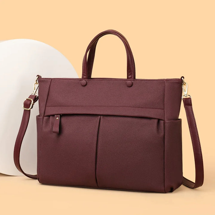 Sac de travail femme Élise en tissu technique noir, porté épaule, style moderne et pratique.
