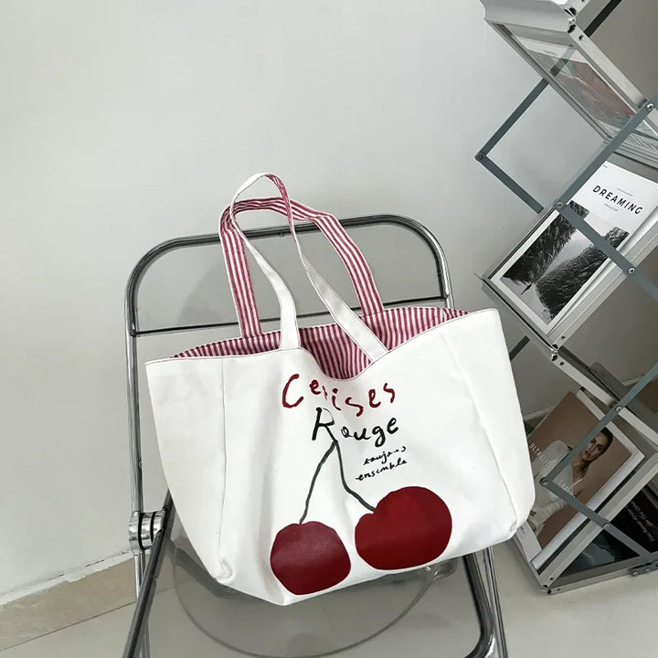 Grand sac shopping réversible en coton imprimé cerises, pratique pour le marché ou comme sac de voyage.