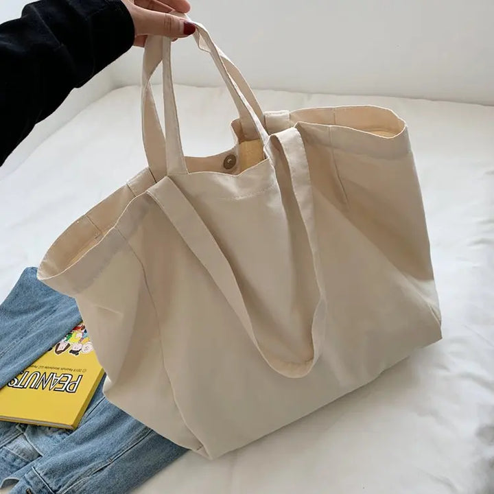 Sac de plage blanc et simple en toile, parfait pour un look estival décontracté