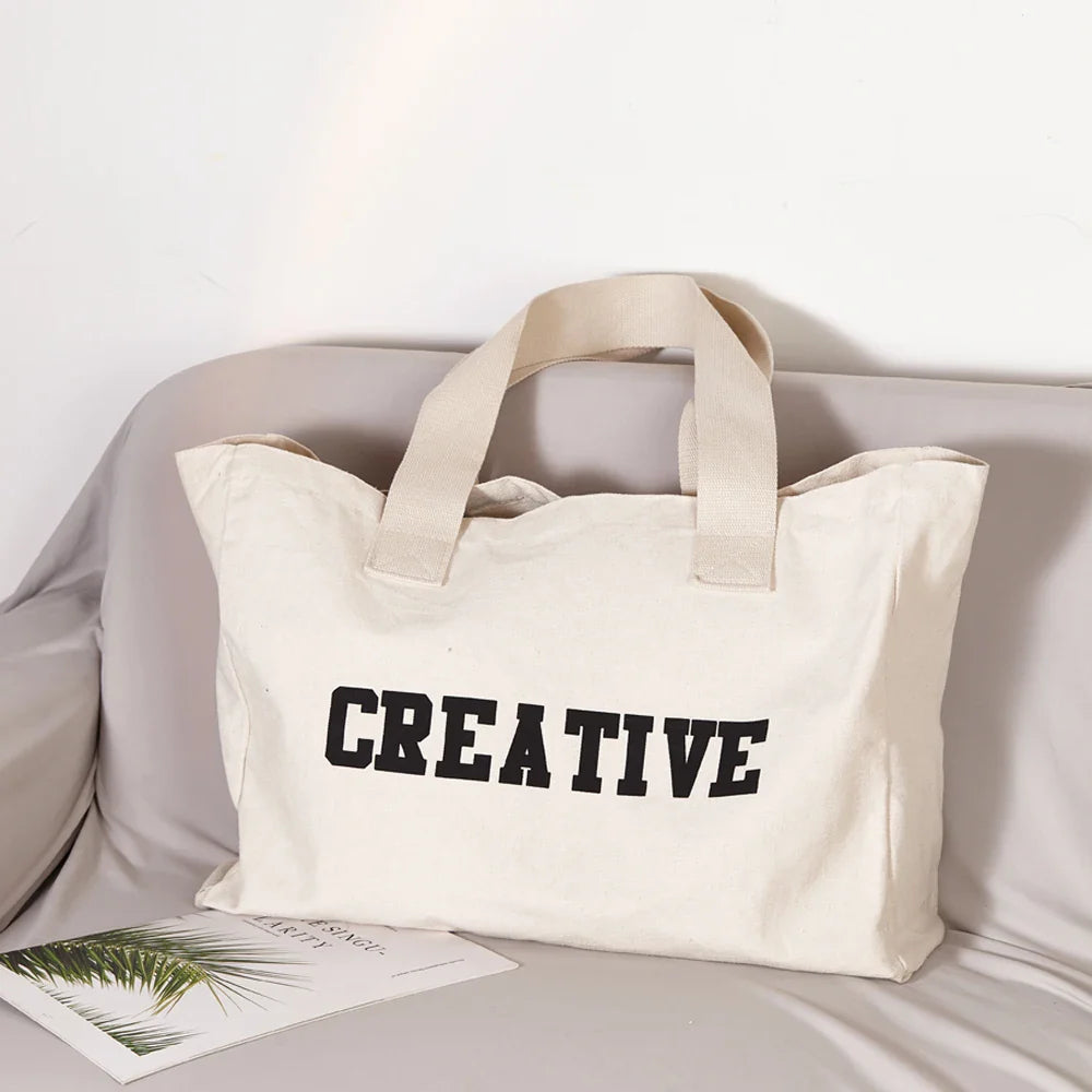 Grand sac de plage en tissu crème pour femme, idéal pour l'été et les voyages.