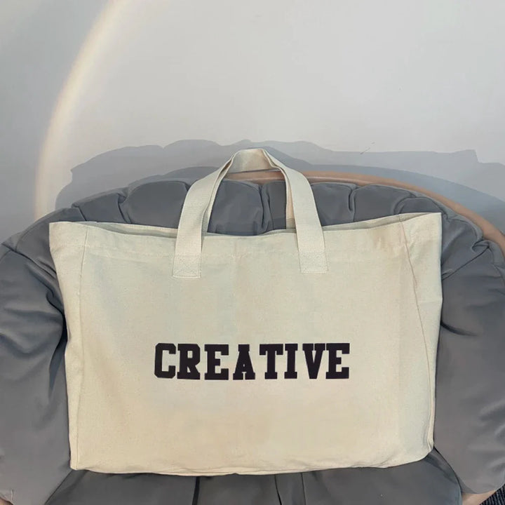 Sac de plage femme en tissu, couleur crème, spacieux et pratique pour tous les voyages estivaux.