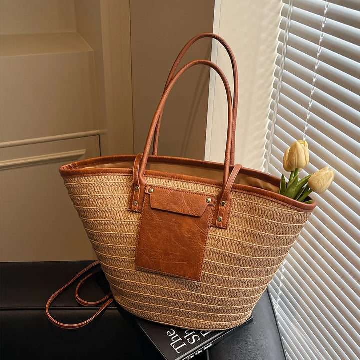 Sac d'été chic femme, modèle Simona, combinant paille naturelle et détails similicuir pour la plage.