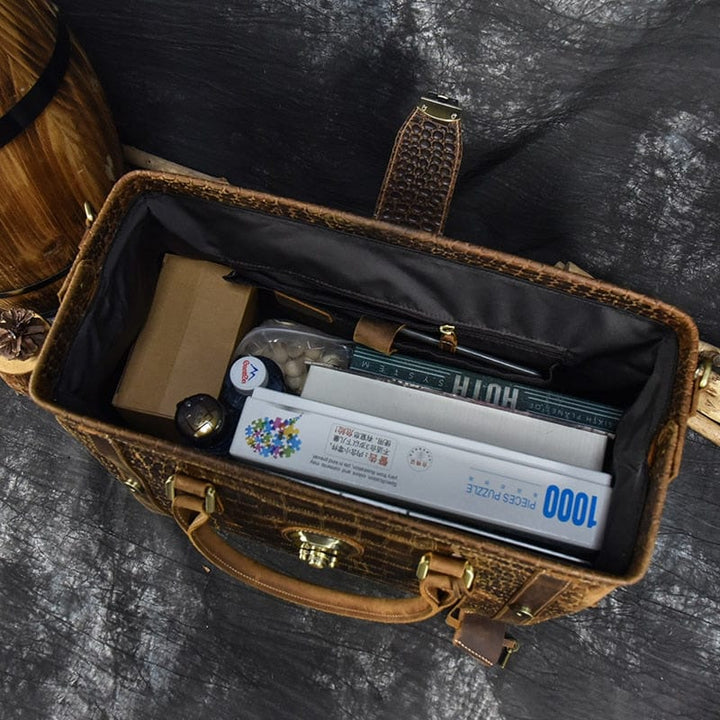 Sac de voyage homme en cuir grainé crocodile, couleur cognac. Pour un look raffiné